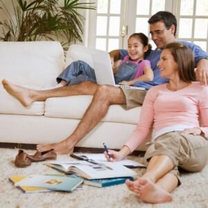 a family relaxing together in a living room looking at papers and a laptop